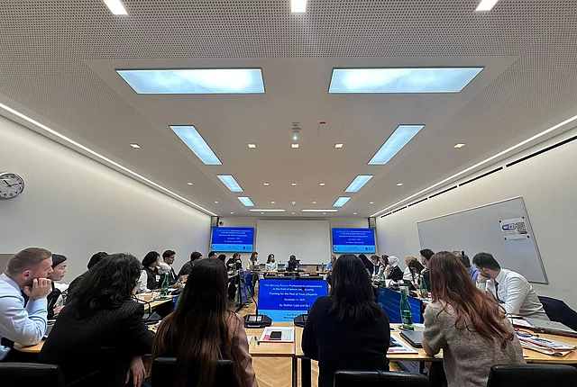 A photo shows a row of participants from the back, their attention captured by the lecture in front of them